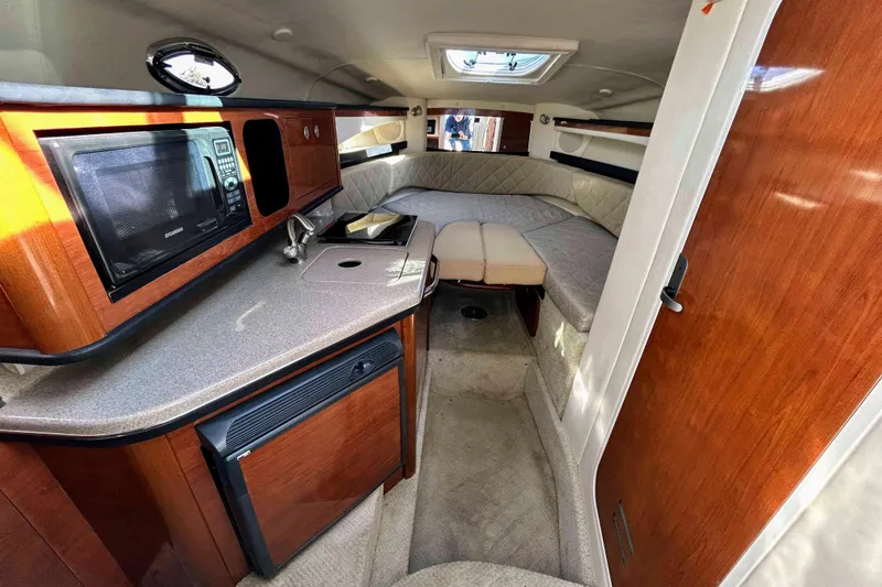 Slide: The Image of Interior of 2007 Sea Ray 260 Sundancer with kitchenette and cozy seating area. - 9