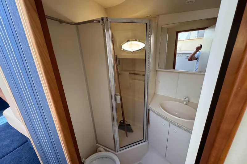 Slide: The Image of 1999 Silverton 392 Motor Yacht interior with beige seating and wooden table. - 13