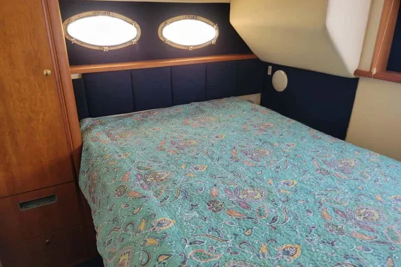 Slide: The Image of 1999 Silverton 392 Motor Yacht cabin with geometric-patterned bedding. - 14
