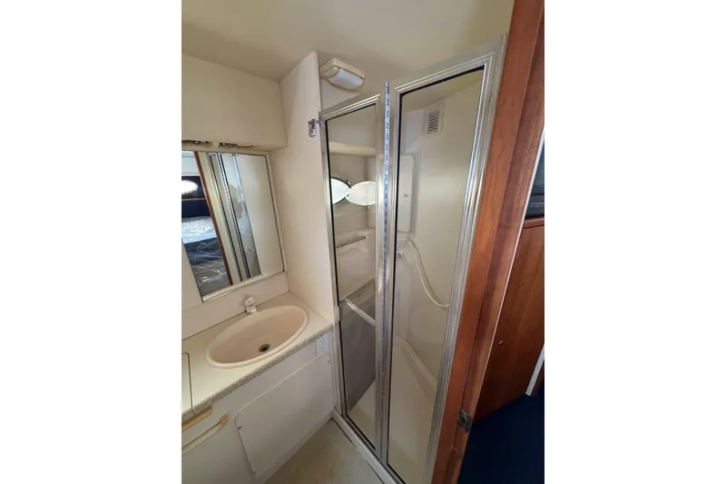 Slide: The Image of Cozy bedroom in 1999 Silverton 392 Motor Yacht with patterned bedspread and porthole windows. - 16