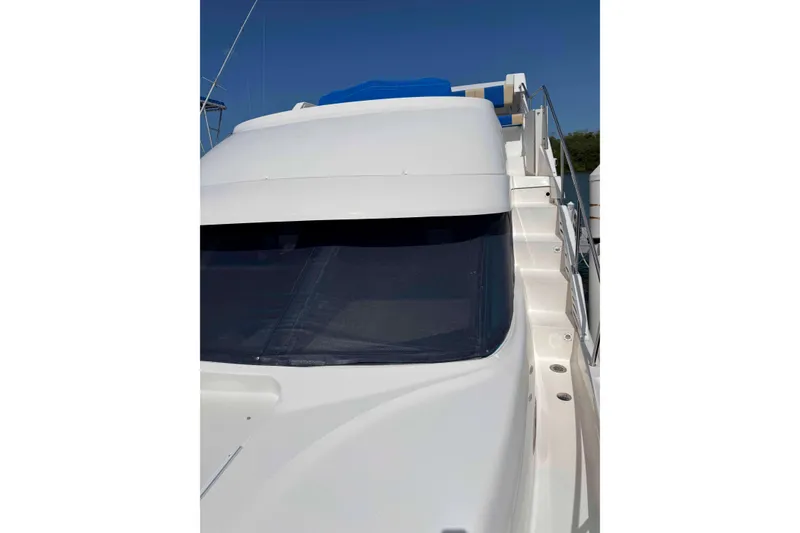 Slide: The Image of 1999 Silverton 392 Motor Yacht docked at marina under clear blue sky. - 2