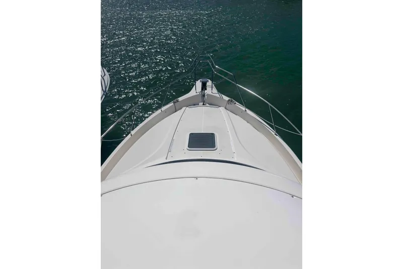 Slide: The Image of 1999 Silverton 392 Motor Yacht helm with steering wheel and control panel, overlooking water. - 7