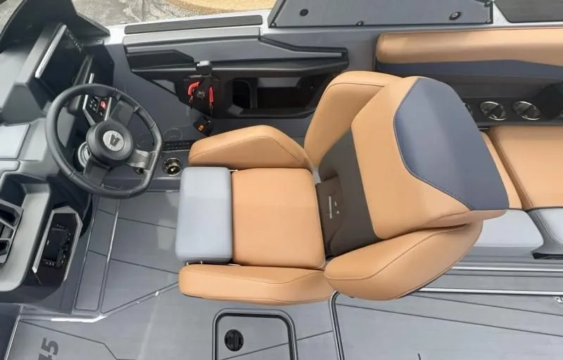 Slide: The Image of 2024 Axis A245 boat interior with tan and gray seating, modern steering wheel, and sleek design. - 11