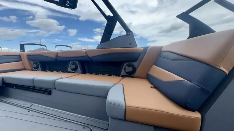 Slide: The Image of 2024 Axis A245 boat interior with tan and gray seating under a blue sky. - 17