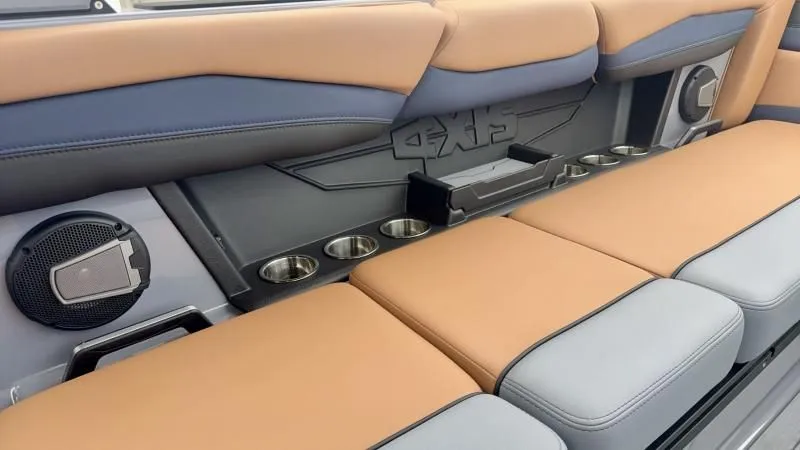 Slide: The Image of 2024 Axis A245 boat interior with tan and gray seating, cup holders, and speakers. - 20