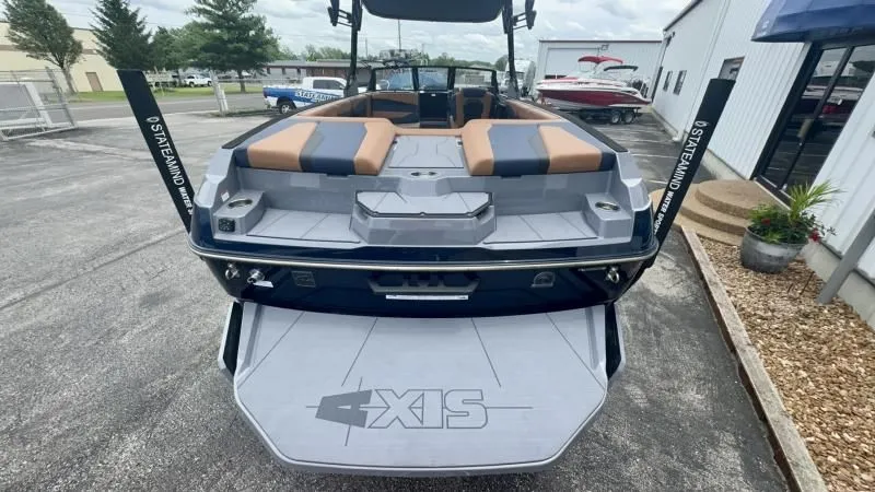 Slide: The Image of 2024 Axis A245 boat rear view with swim platform and seating, parked outdoors. - 24