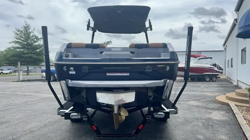 Slide: The Image of 2024 Axis A245 boat rear view, parked outdoors, showcasing propeller and swim platform. - 3