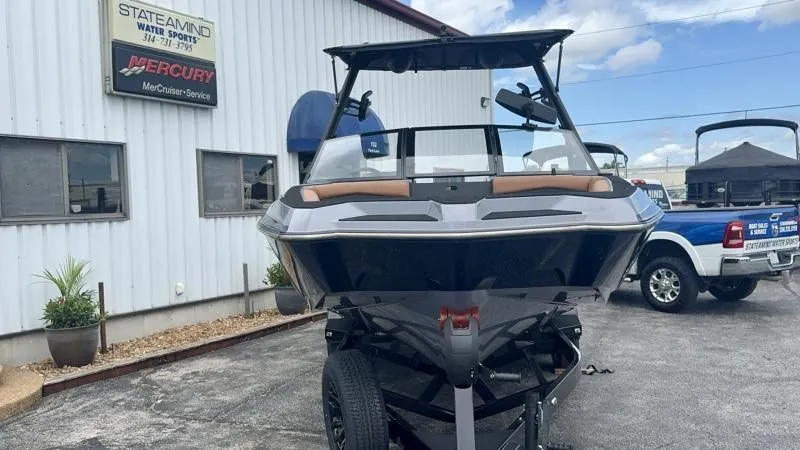 Slide: The Image of 2024 Axis A245 boat on trailer at dealership, with building and truck in background. - 7