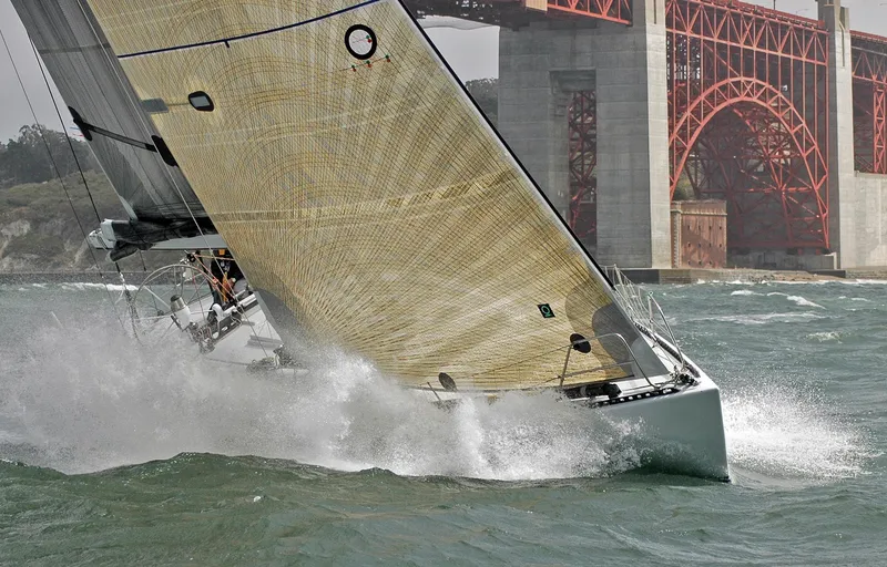 Slide: The Image of Sailing yacht Santa Cruz SC 50 from 1980 under a large red bridge. - 11