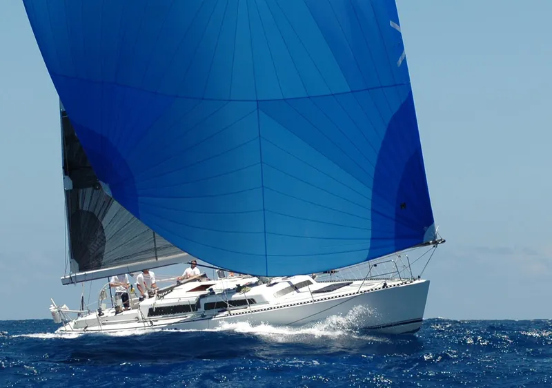 Slide: The Image of 1980 Santa Cruz SC 50 sailboat with blue spinnaker on open sea. - 12