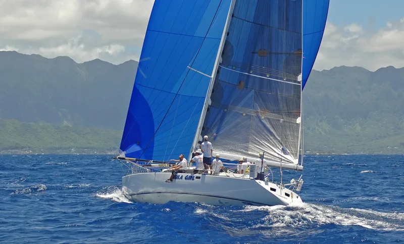 Slide: The Image of Sailing yacht Santa Cruz SC 50, 1980, with blue sails on ocean, mountainous backdrop. - 13