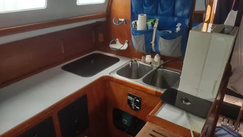 Slide: The Image of 1980 Santa Cruz SC 50 yacht kitchen with dual sinks and wooden cabinetry. - 24