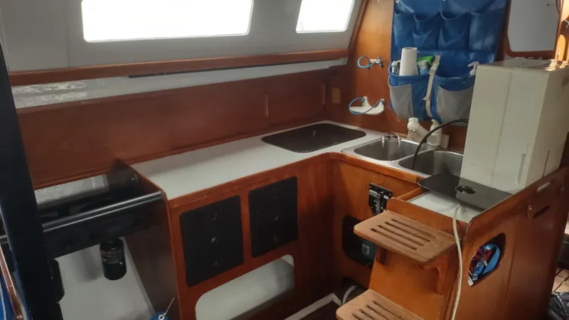 Slide: The Image of Interior of 1980 Santa Cruz SC 50 sailboat kitchen with wooden cabinetry and sink. - 25