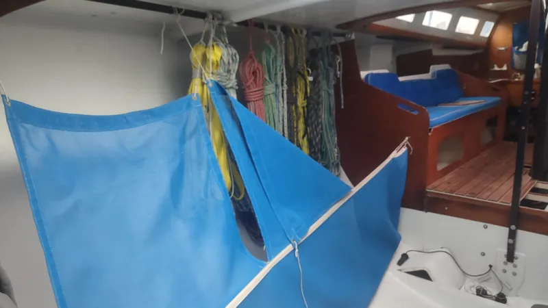Slide: The Image of Interior of a 1980 Santa Cruz 50 sailboat with blue hammock and ropes. - 30