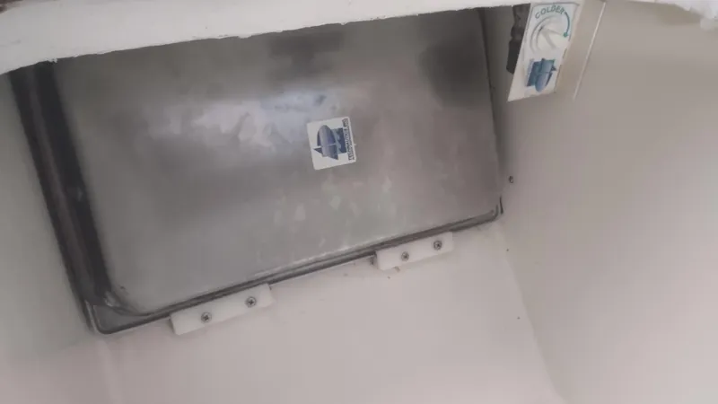 Slide: The Image of Interior view of a 1980 Santa Cruz SC 50 boat compartment with a metal panel. - 38