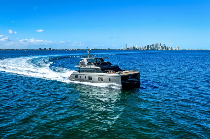 The Image of Luxury Sunreef 60 Power yacht cruising near city skyline, 2026 model. - 0