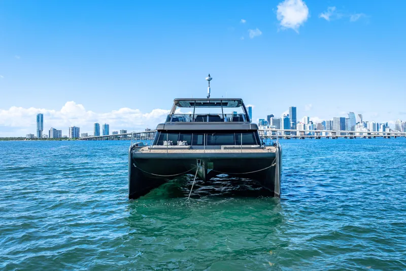 Slide: The Image of 2026 Sunreef 60 Power yacht on blue water with city skyline backdrop. - 15