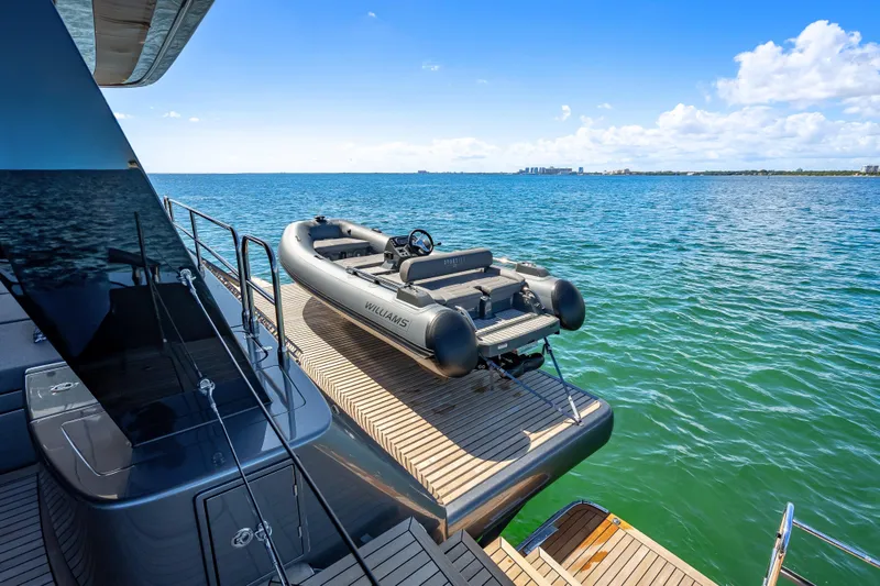 Slide: The Image of 2026 Sunreef 60 Power yacht with tender on deck, overlooking serene ocean view. - 17