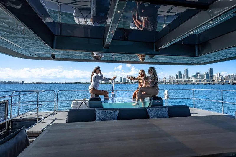 Slide: The Image of Luxurious Sunreef 60 Power yacht with people enjoying the deck, city skyline in background, 2026 model. - 21