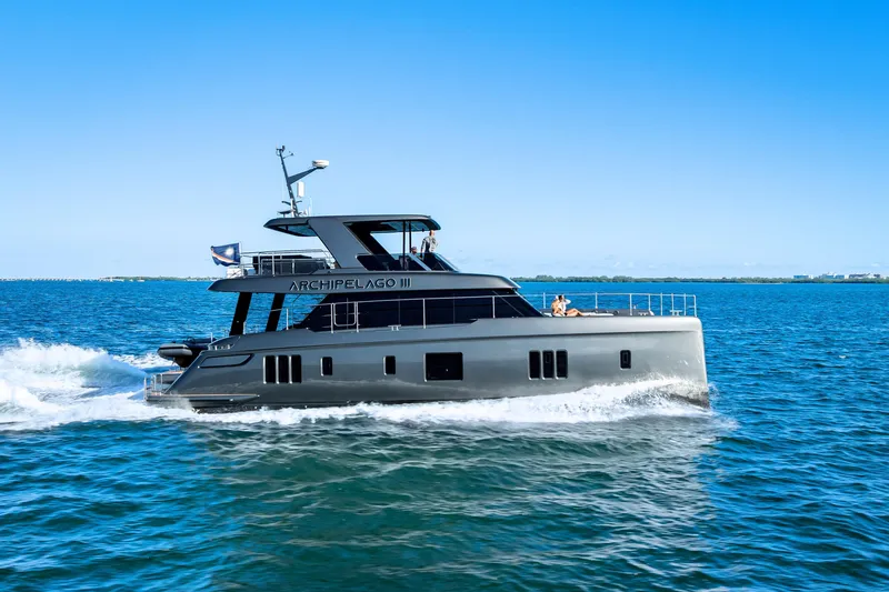Slide: The Image of 2026 Sunreef 60 Power yacht cruising on open water under clear blue skies. - 3