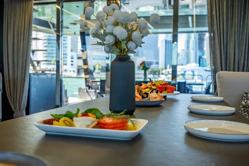 Slide: The Image of Luxurious dining setup on 2026 Sunreef 60 Power yacht with cityscape view. - 49