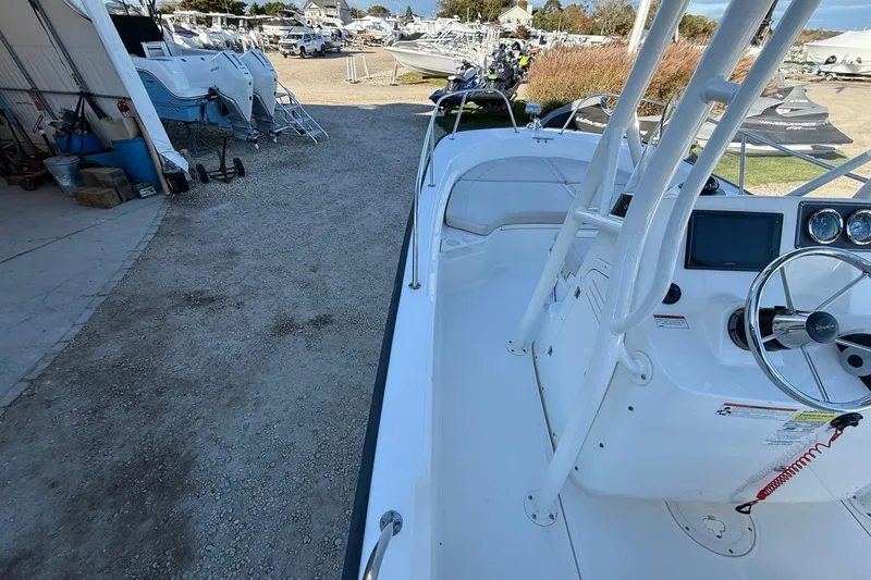 Slide: The Image of 2021 Boston Whaler 190 Montauk boat interior with steering console, parked outdoors. - 16