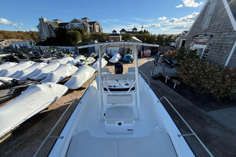 Slide: The Image of 2021 Boston Whaler 190 Montauk boat at marina with jet skis and coastal buildings. - 19