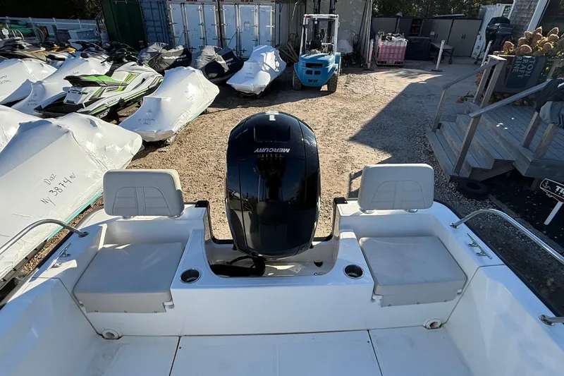 Slide: The Image of 2021 Boston Whaler 190 Montauk boat with Mercury engine, surrounded by covered jet skis. - 8