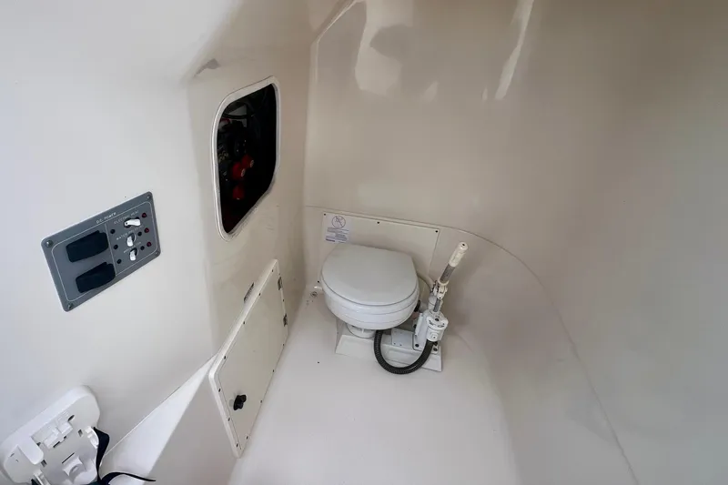 Slide: The Image of 2005 Pursuit 2670 Center Console boat interior with marine toilet and control panel. - 12