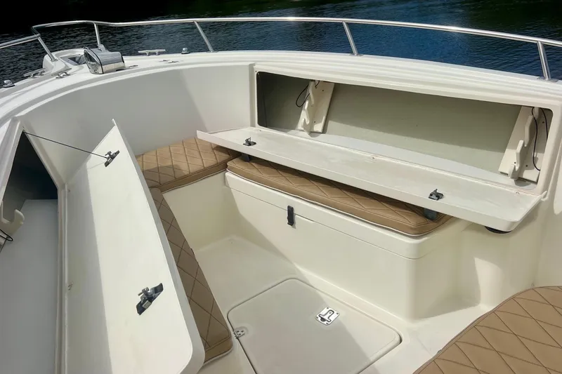Slide: The Image of 2005 Pursuit 2670 Center Console boat with open storage compartments and cushioned seating. - 16
