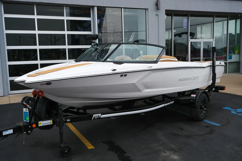 Slide: The Image of 2026 MasterCraft ProStar 190 boat on trailer, parked outside a showroom. - 5