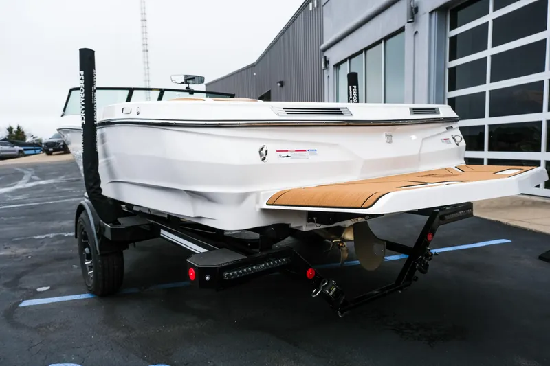 Slide: The Image of 2026 MasterCraft ProStar 190 boat on trailer, rear view, parked outside a building. - 6