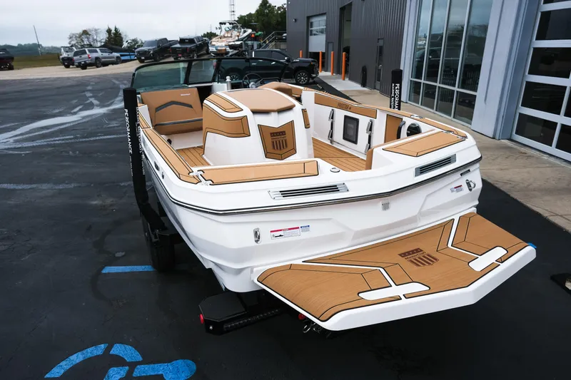 Slide: The Image of 2026 MasterCraft ProStar 190 boat with sleek design, parked outside a modern building. - 7