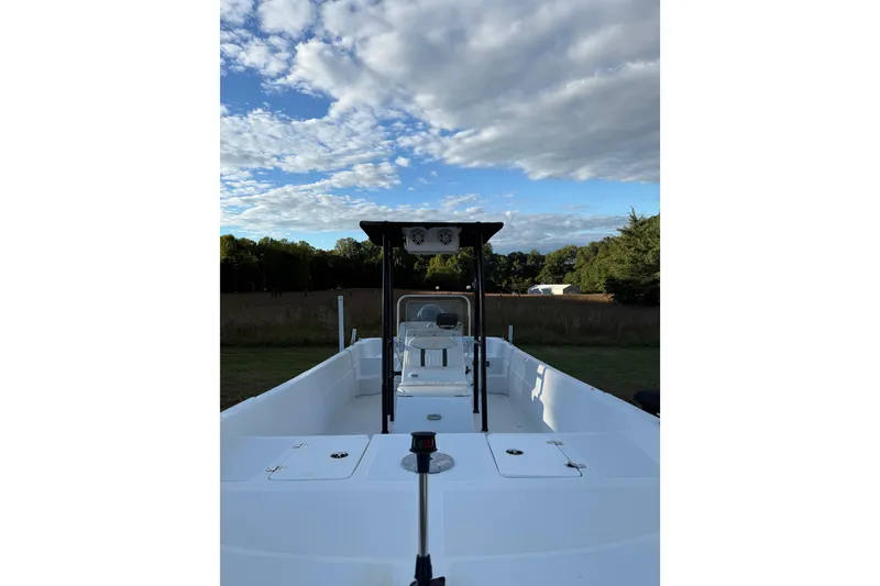 Slide: The Image of 2009 Carolina Skiff 218 DLV boat under a partly cloudy sky, parked on grass. - 4