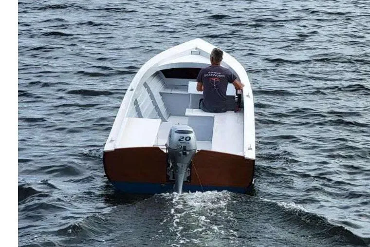 Slide: The Image of Custom Uffa Fox 2023 boat with outboard motor on open water. - 2