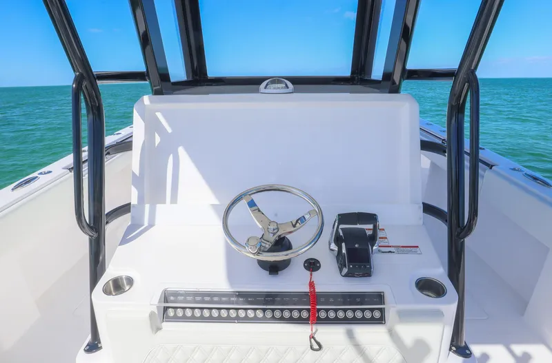 Slide: The Image of 2025 Invincible 35 Catamaran helm with ocean view, featuring steering wheel and controls. - 18