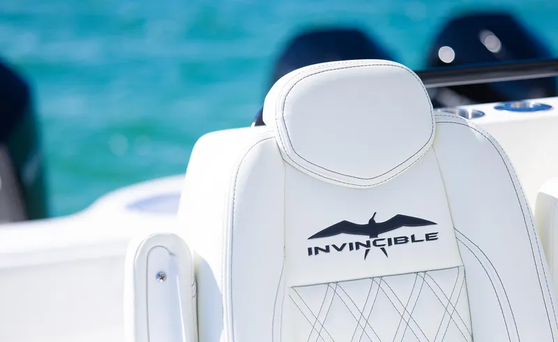Slide: The Image of Invincible 35 Catamaran 2025, white seat detail with logo, ocean background. - 20
