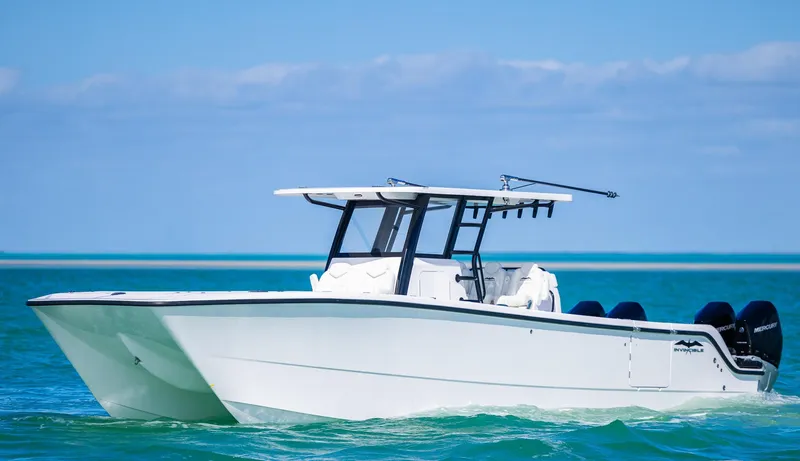 Slide: The Image of 2025 Invincible 35 Catamaran cruising on clear blue water. - 36