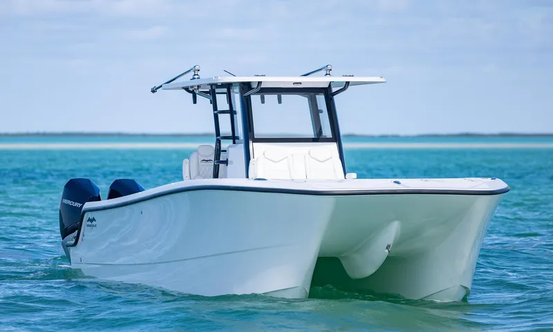 Slide: The Image of 2025 Invincible 35 Catamaran on turquoise water, showcasing sleek design and twin engines. - 38