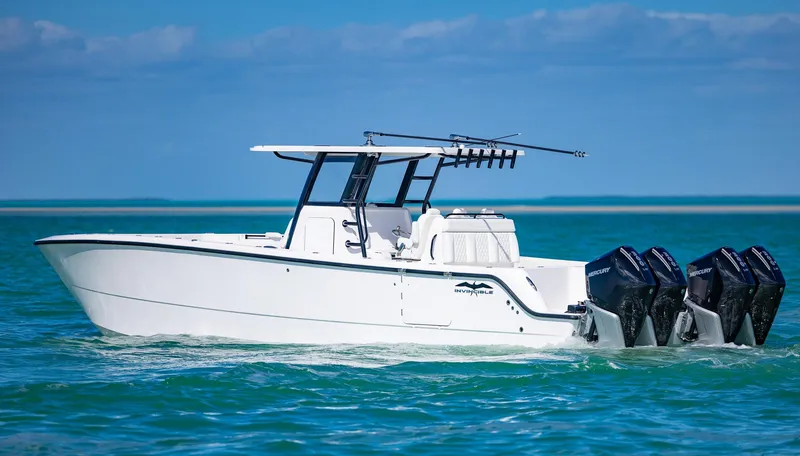 Slide: The Image of 2025 Invincible 35 Catamaran cruising on turquoise waters with triple outboard engines. - 46