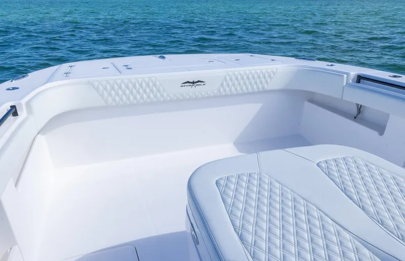 Slide: The Image of 2025 Invincible 35 Catamaran interior with quilted seating, ocean backdrop. - 8