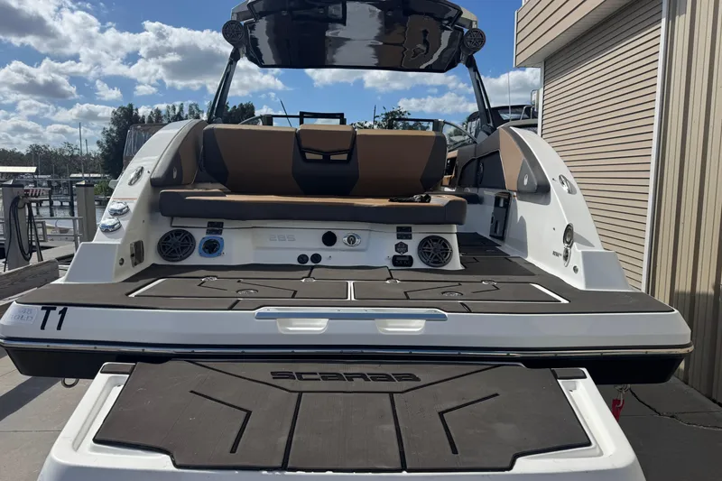 Slide: The Image of 2022 Scarab 285 ID boat, rear view, docked under a partly cloudy sky. - 11