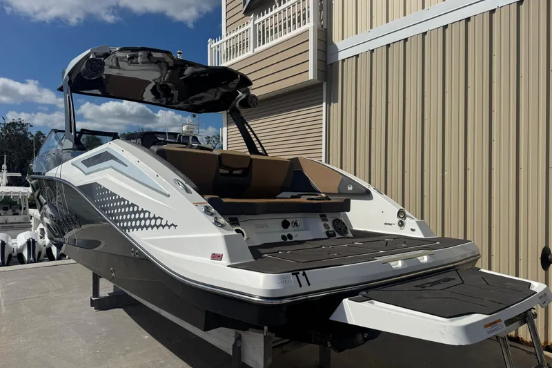 Slide: The Image of 2022 Scarab 285 ID boat with sleek design, docked near a beige building. - 14
