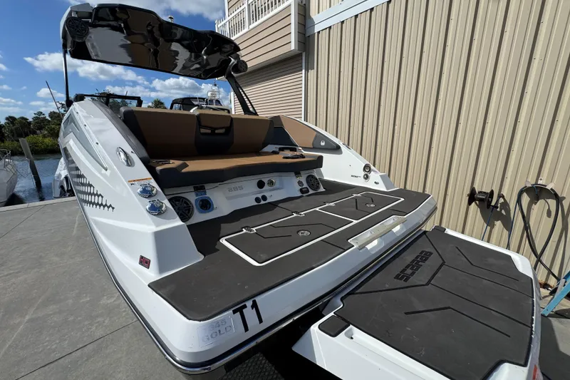 Slide: The Image of 2022 Scarab 285 ID boat with sleek design, docked by a wooden building. - 16