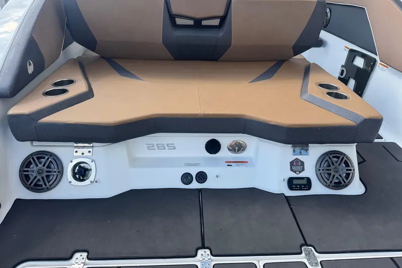 Slide: The Image of 2022 Scarab 285 ID boat interior with brown seating, cup holders, and speakers. - 17