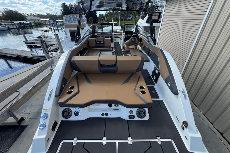 Slide: The Image of 2022 Scarab 285 ID boat with sleek design and spacious seating at a marina. - 19
