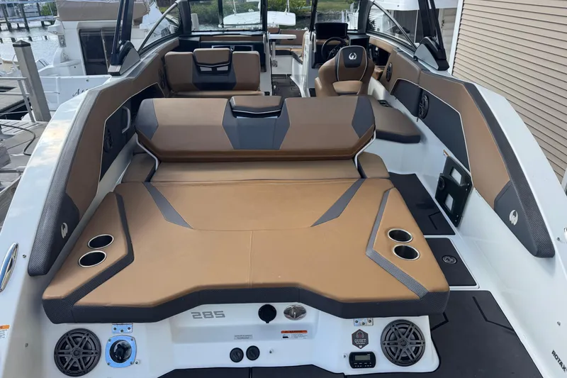 Slide: The Image of 2022 Scarab 285 ID boat interior with brown seating and cup holders. - 22