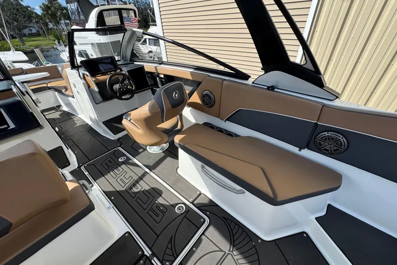 Slide: The Image of 2022 Scarab 285 ID boat interior with brown seating, modern dashboard, and sleek design. - 29