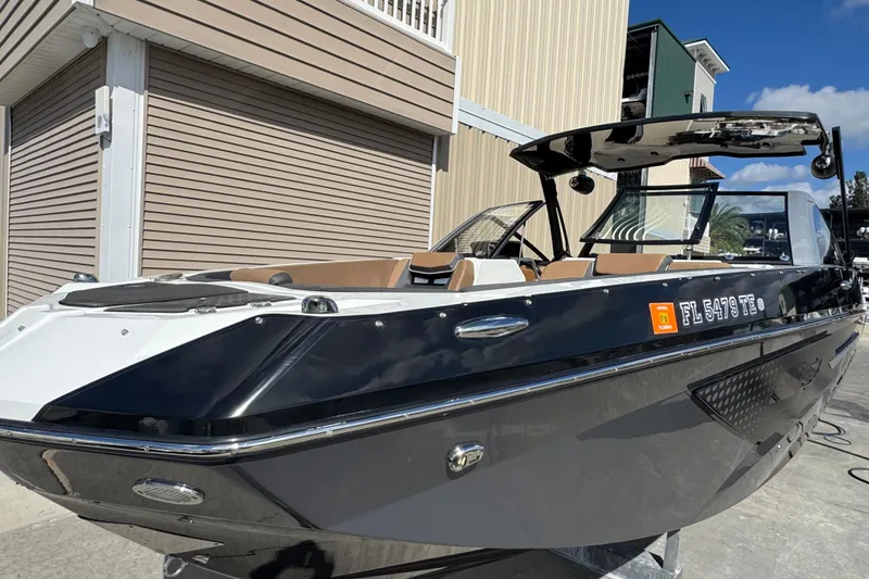 Slide: The Image of 2022 Scarab 285 ID boat with sleek black and white design, docked outdoors. - 3