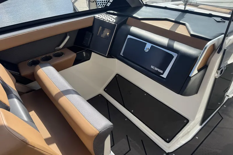 Slide: The Image of Interior of 2022 Scarab 285 ID boat with brown and black seating and dashboard. - 33